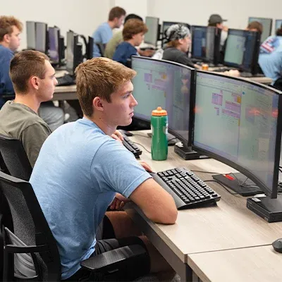 Two students looking at tables on computer screens.