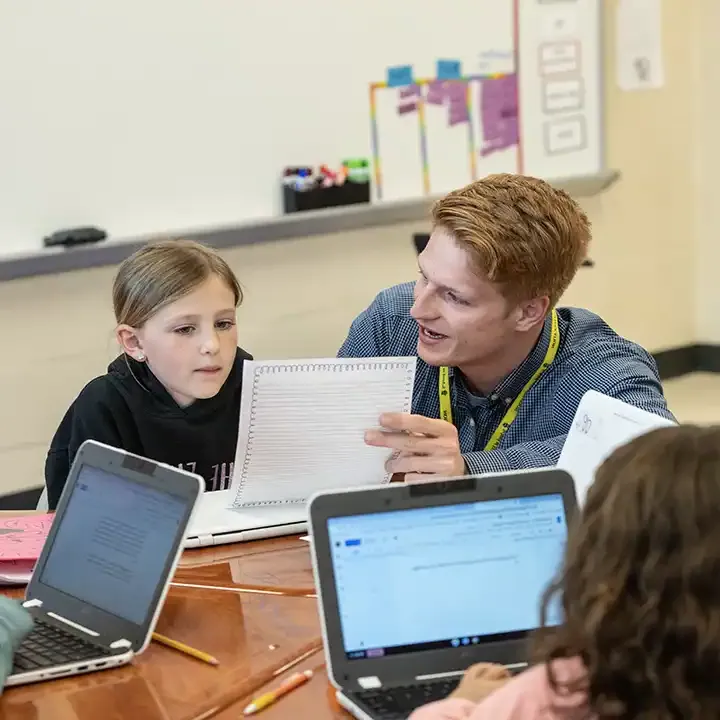 Male teacher educating a small group of children.