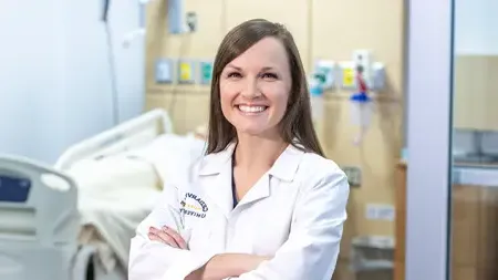 Female nursing faculty wearing a white lab coat.