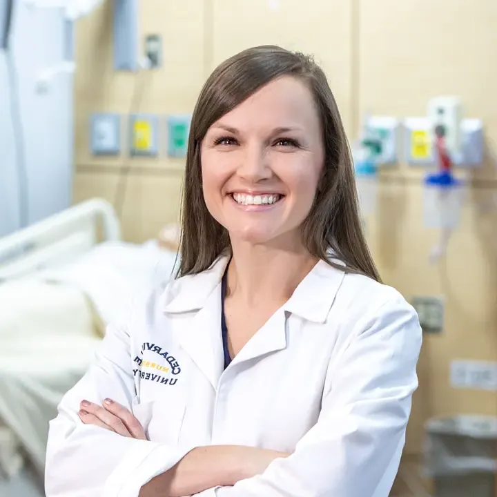 Female nursing faculty wearing a white lab coat.