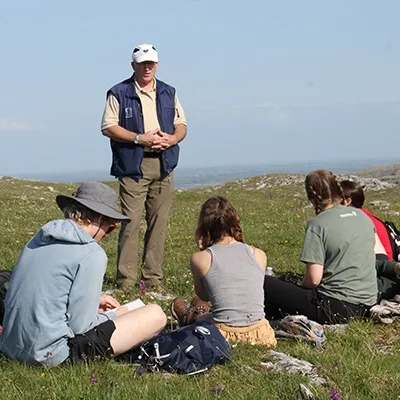 Professor leading geology students on a trip in the mountains.