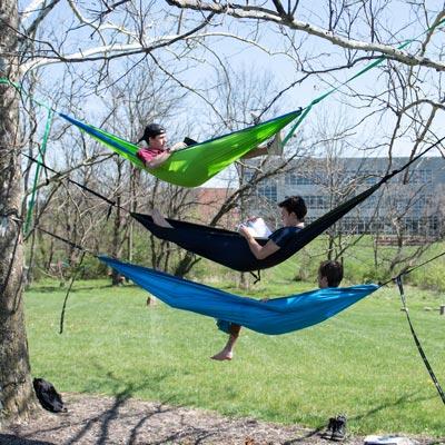 three students in hammocks reading books